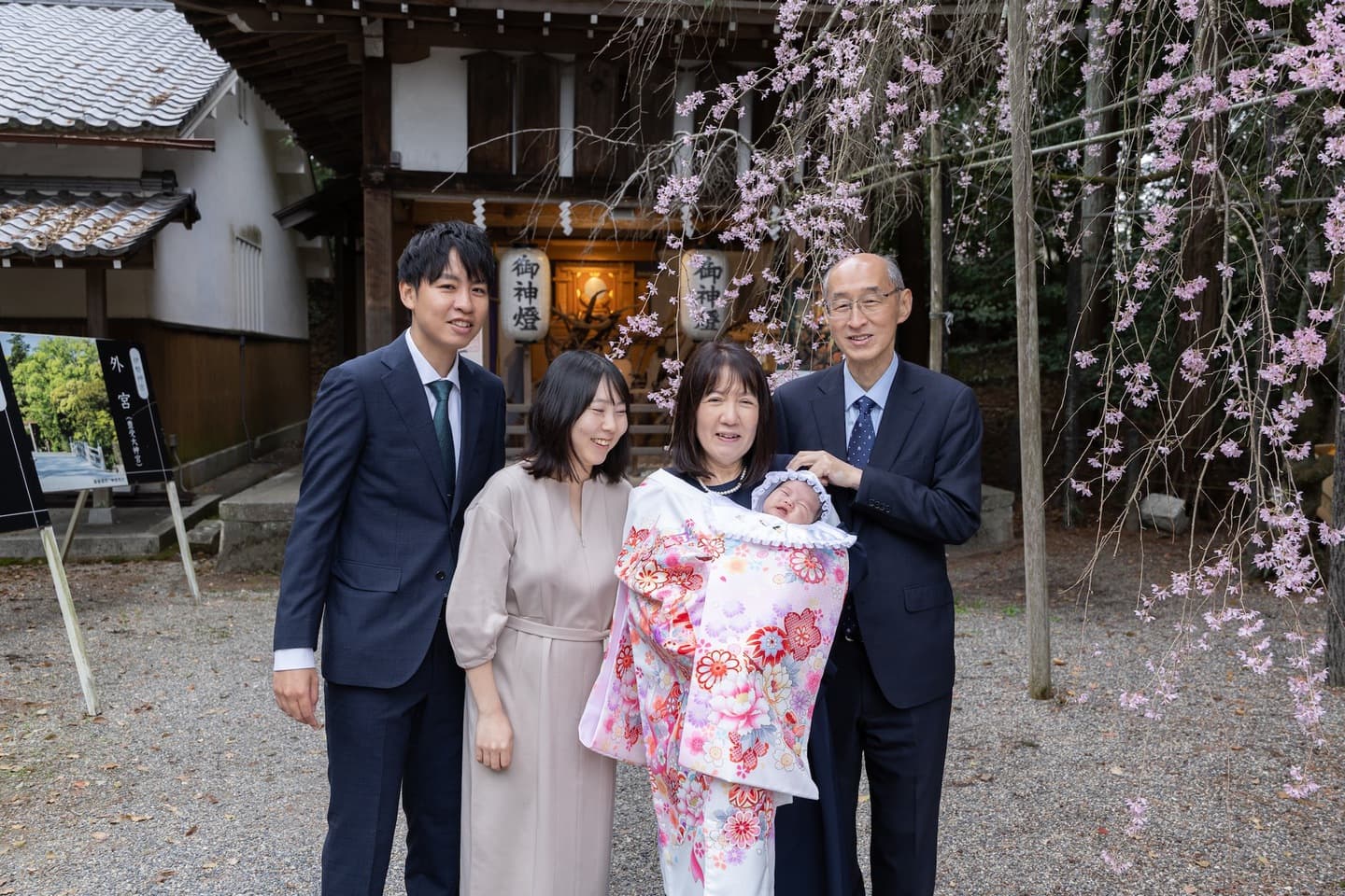 神社でお宮参りの赤ちゃんと家族