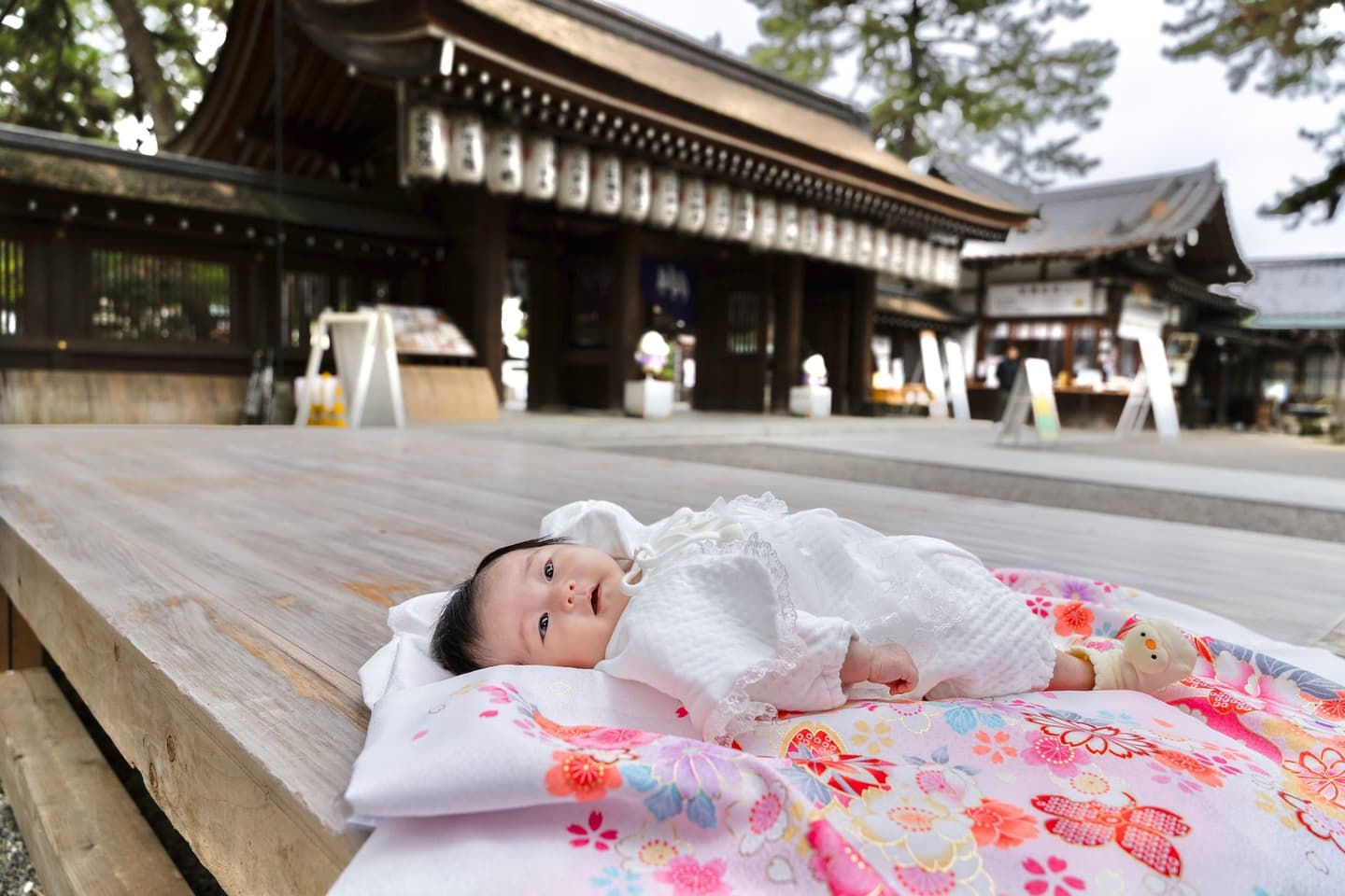 神社でお宮参りの赤ちゃんと家族