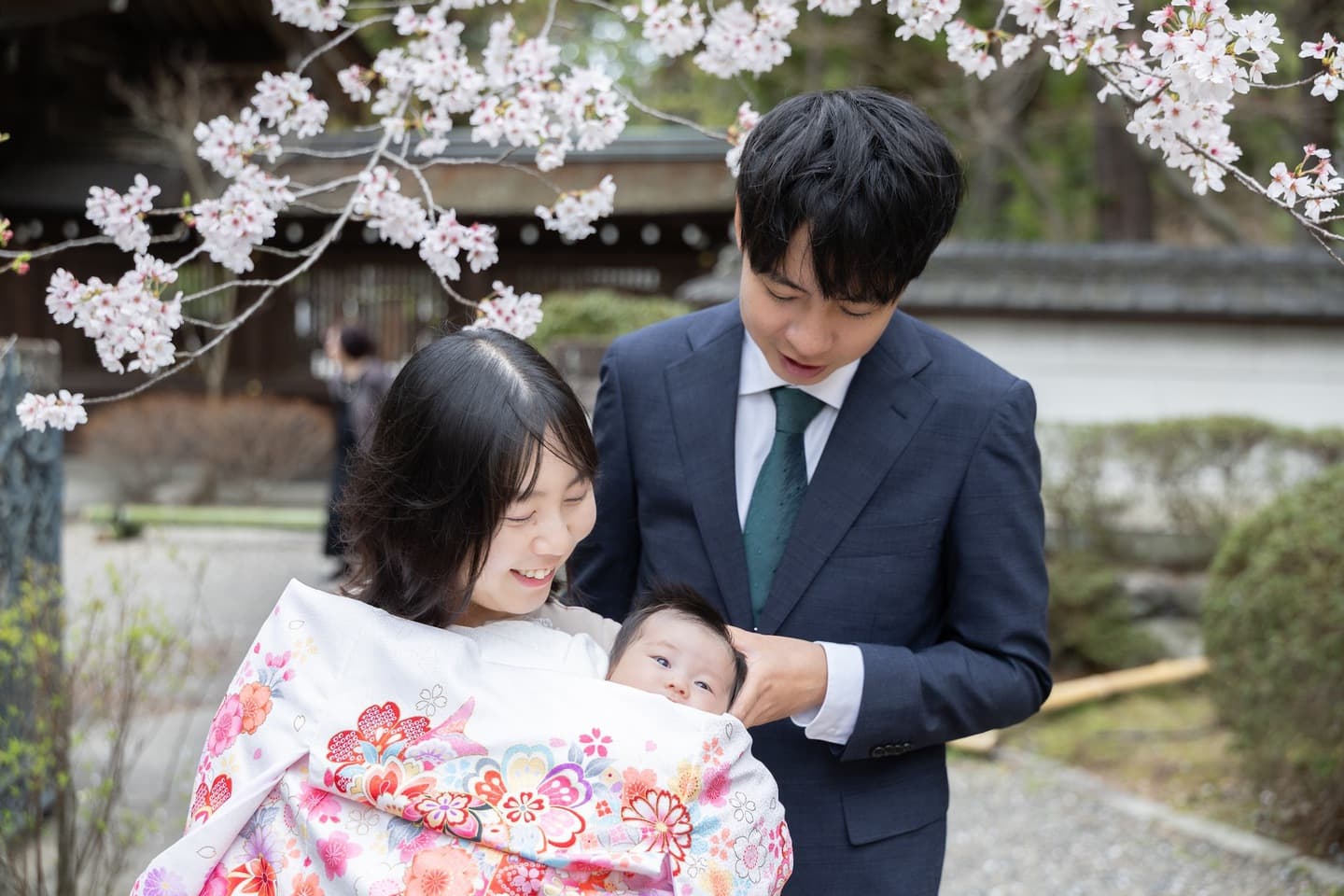神社でお宮参りの赤ちゃんと家族