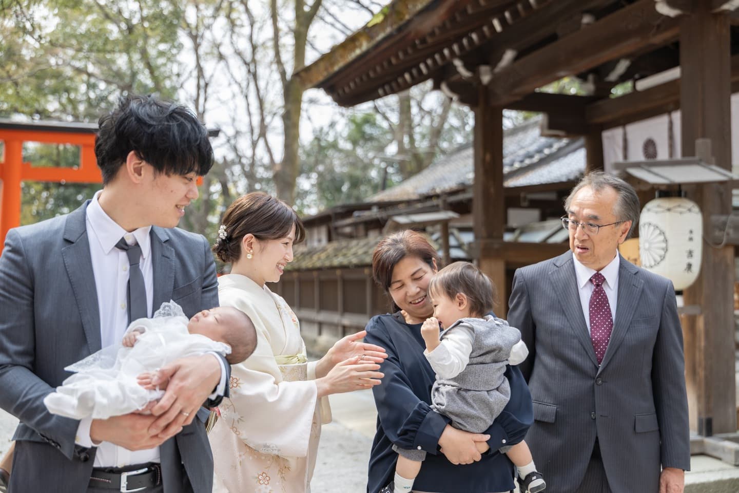 神社でお宮参りの赤ちゃんと家族