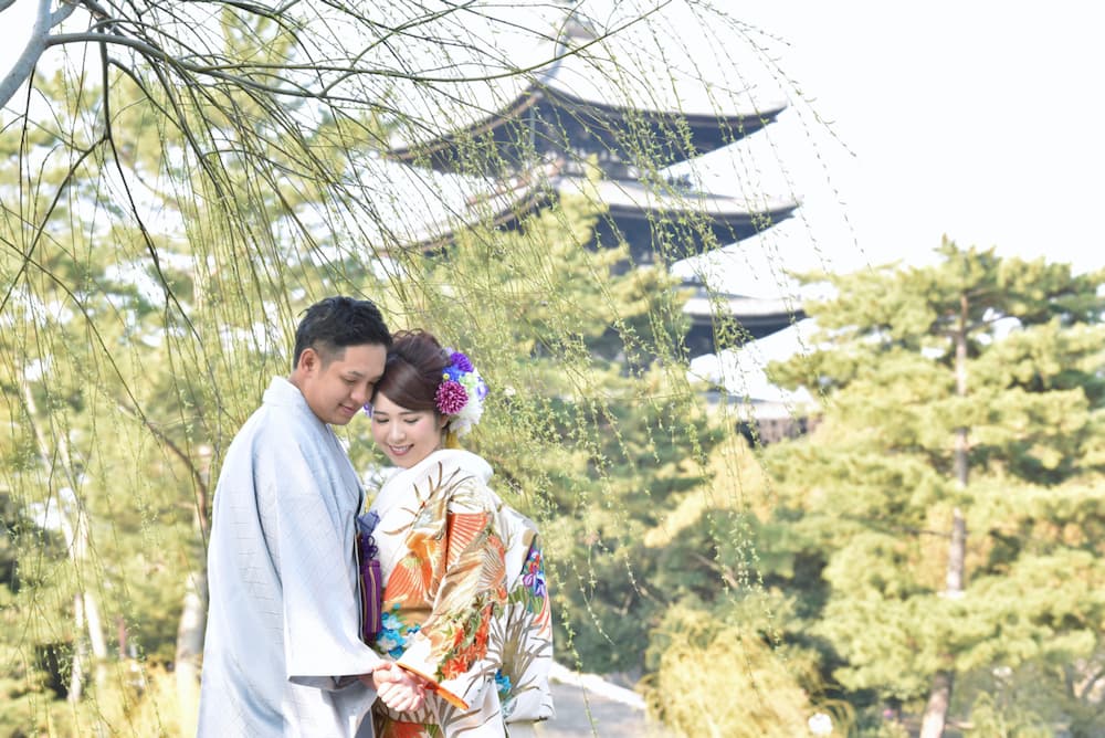 色打掛を着た花嫁様と新郎様が手を繋いでいる