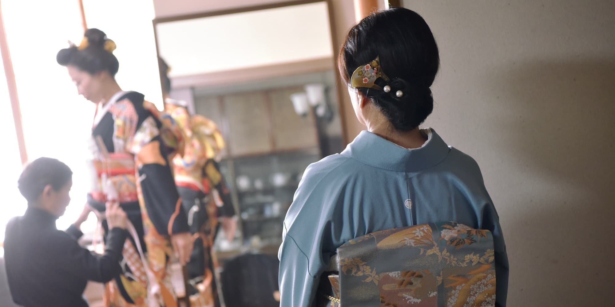 娘の花嫁着付けを見つめる母