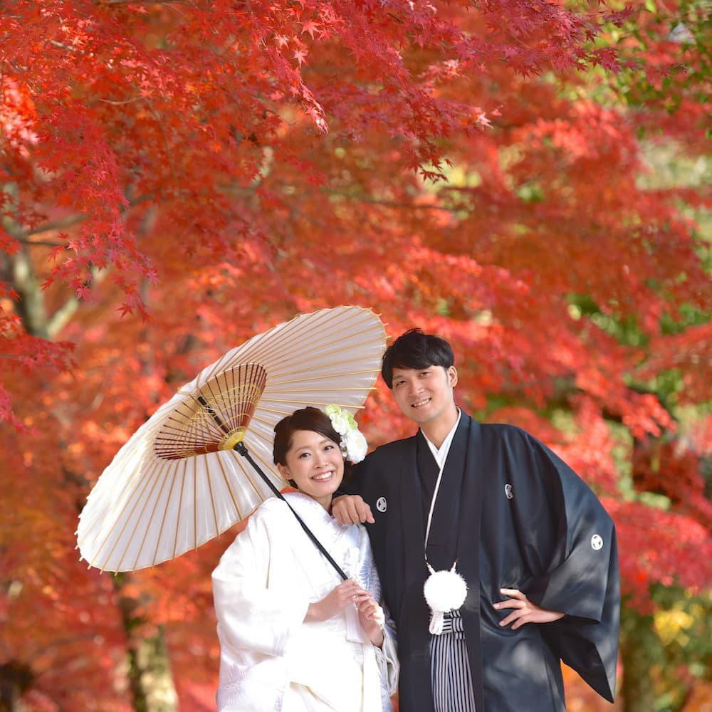 白無垢を着た花嫁様と紋付羽織袴を着た新郎様が笑っている